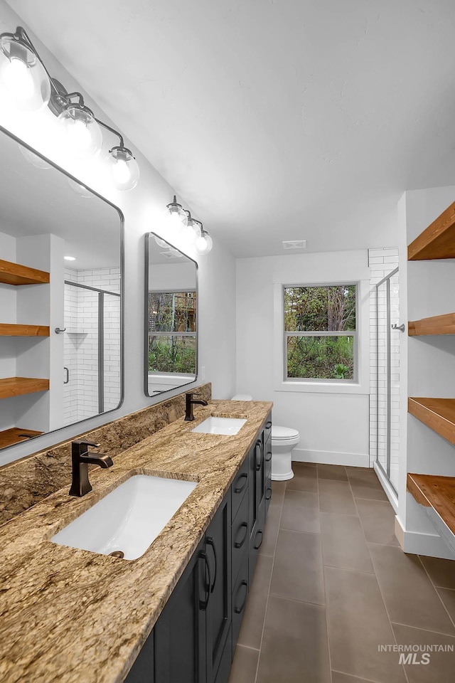 1 Caribou Pkwy, Cascade, ID 83611 - full bathroom featuring a stall shower, tile patterned floors, double vanity, toilet, and baseboards