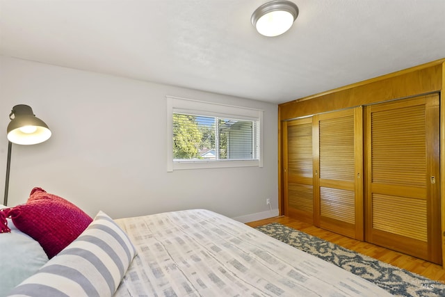 bedroom featuring a closet, baseboards, and wood finished floors