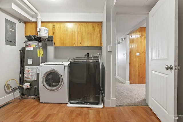 washroom with washer and clothes dryer, light wood-type flooring, water heater, electric panel, and cabinet space