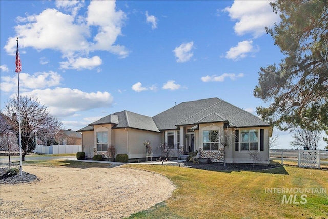 view of front of house featuring a front yard, fence, and stucco siding