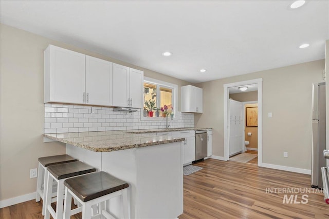 3600 S Robinson Blvd, Nampa, ID 83686 - kitchen featuring stainless steel dishwasher, white cabinets, backsplash, a breakfast bar area, and recessed lighting