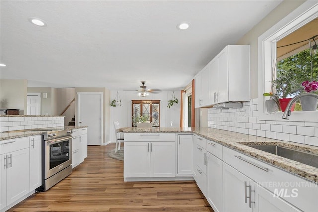 3600 S Robinson Blvd, Nampa, ID 83686 - kitchen with high end stainless steel range, a peninsula, backsplash, healthy amount of natural light, and recessed lighting