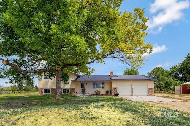 3600 S Robinson Blvd, Nampa, ID 83686 - split level home featuring a garage, solar panels, a front lawn, driveway, and brick siding