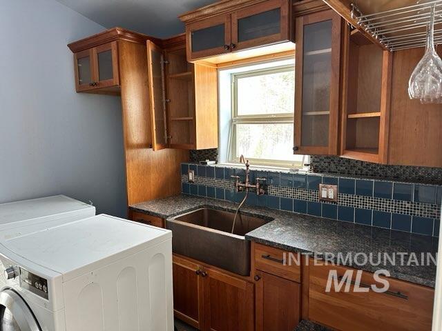 kitchen featuring sink, tasteful backsplash, and dark stone counters