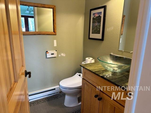 bathroom with a baseboard radiator, toilet, and vanity