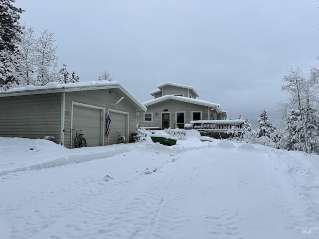 snow covered property featuring a garage