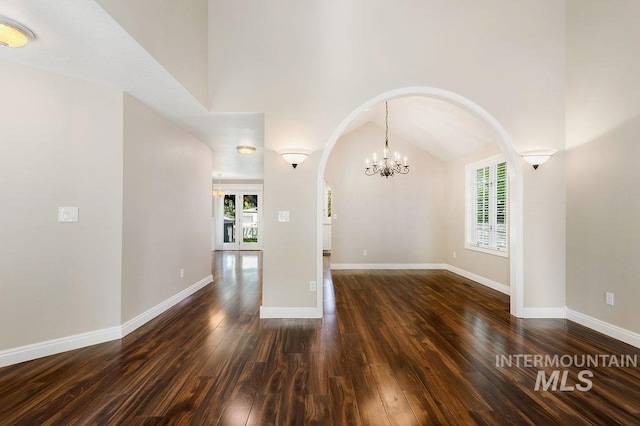 2500 W Orchard Ave, Nampa, ID 83651 - spare room with arched walkways, a notable chandelier, dark wood finished floors, and a healthy amount of sunlight