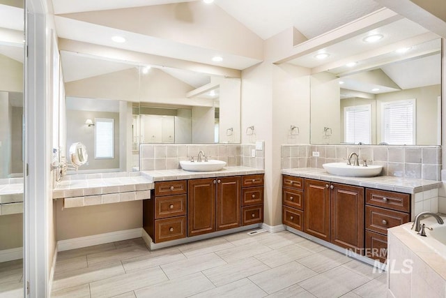 2500 W Orchard Ave, Nampa, ID 83651 - bathroom with a sink, two vanities, vaulted ceiling, and tasteful backsplash