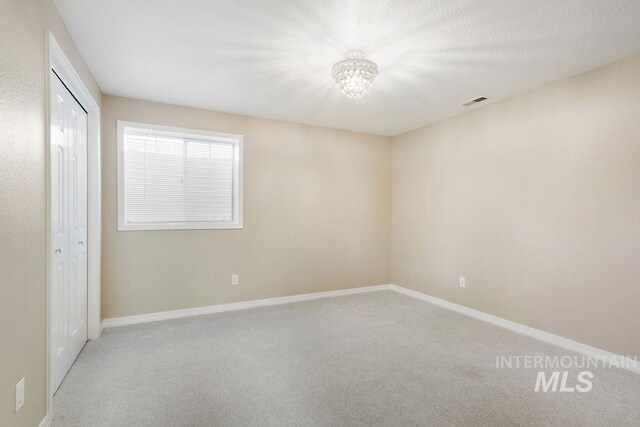 2500 W Orchard Ave, Nampa, ID 83651 - carpeted spare room with an inviting chandelier, baseboards, and visible vents
