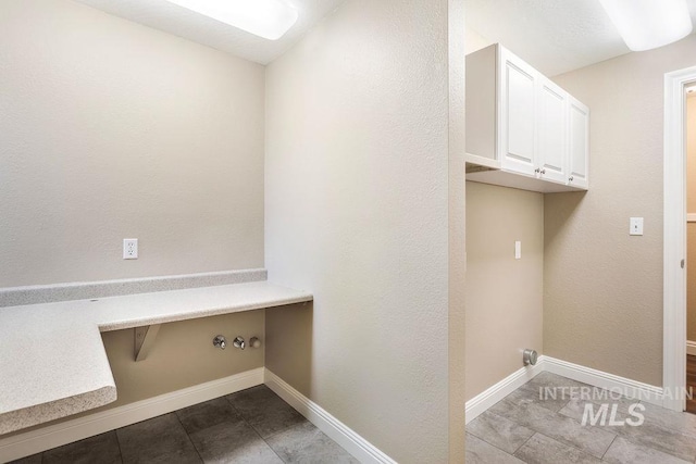 2500 W Orchard Ave, Nampa, ID 83651 - laundry area with tile patterned flooring, cabinet space, baseboards, and washer hookup