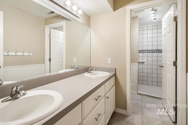 2500 W Orchard Ave, Nampa, ID 83651 - bathroom with a sink, tile patterned flooring, a tile shower, and double vanity