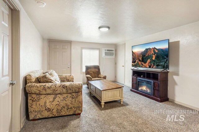 2500 W Orchard Ave, Nampa, ID 83651 - living area with a glass covered fireplace, baseboards, an AC wall unit, a textured ceiling, and carpet flooring