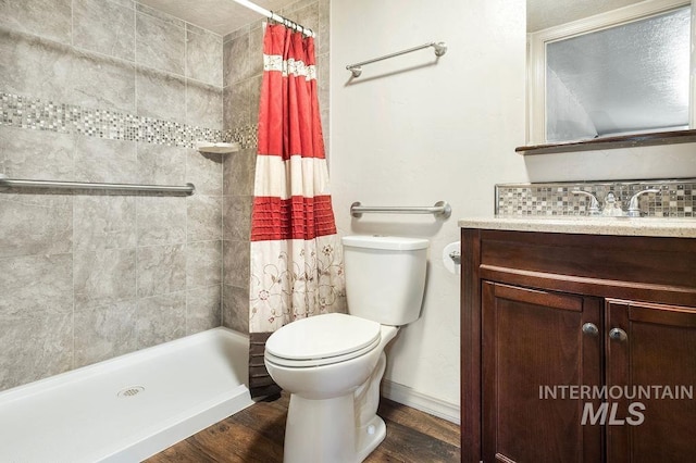 2500 W Orchard Ave, Nampa, ID 83651 - bathroom featuring wood finished floors, vanity, baseboards, toilet, and tiled shower