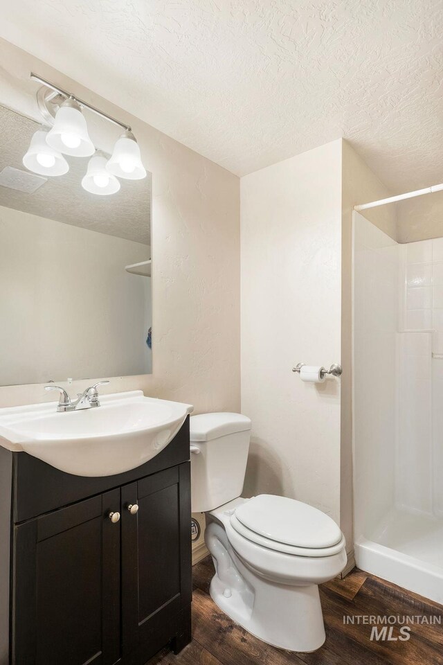 2500 W Orchard Ave, Nampa, ID 83651 - bathroom featuring a textured ceiling, toilet, and wood finished floors