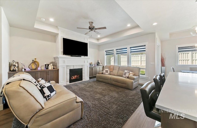 4603 S Hennessy Ave, Meridian, ID 83642 - living room with a raised ceiling, wood finished floors, a ceiling fan, a tiled fireplace, and recessed lighting