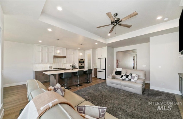 4603 S Hennessy Ave, Meridian, ID 83642 - living room featuring recessed lighting, dark wood-type flooring, a raised ceiling, and ceiling fan