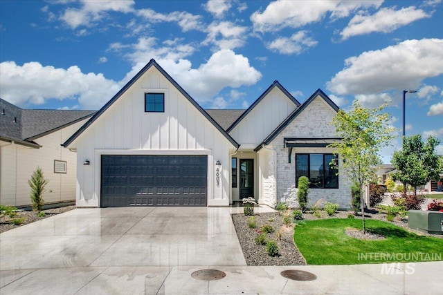 4603 S Hennessy Ave, Meridian, ID 83642 - view of front of house with board and batten siding, stone siding, driveway, and an attached garage