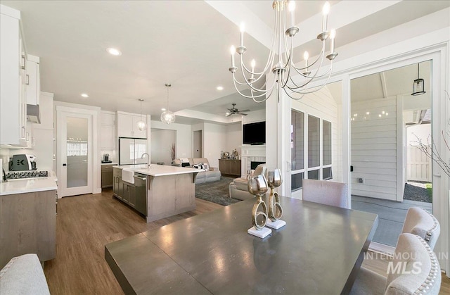 4603 S Hennessy Ave, Meridian, ID 83642 - dining area with a chandelier, dark wood-style floors, ceiling fan, recessed lighting, and a fireplace