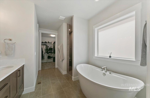 4603 S Hennessy Ave, Meridian, ID 83642 - bathroom with a walk in closet, a freestanding bath, vanity, a stall shower, and tile patterned flooring
