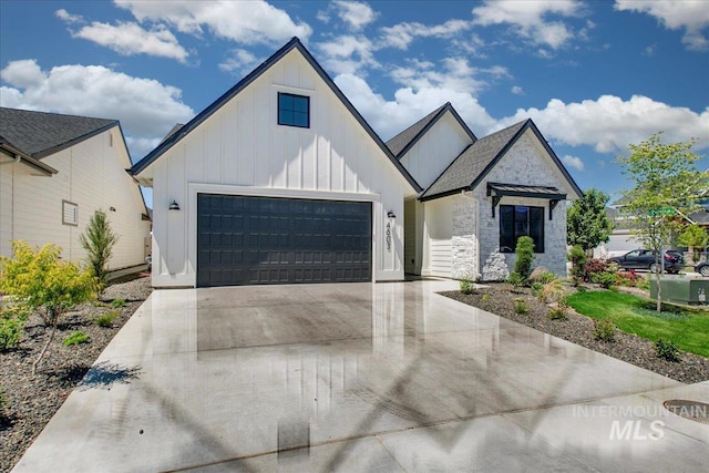 4603 S Hennessy Ave, Meridian, ID 83642 - view of front of property featuring board and batten siding, concrete driveway, a garage, and stone siding