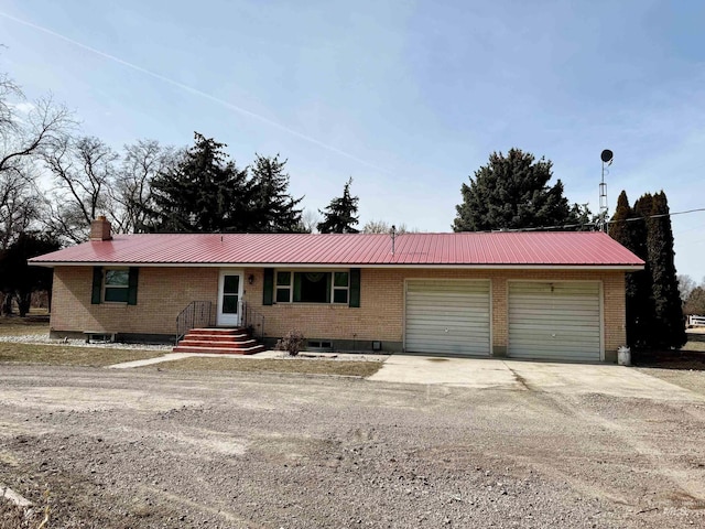 ranch-style house featuring dirt driveway, a chimney, metal roof, an attached garage, and brick siding