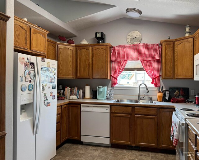 kitchen featuring lofted ceiling, sink, and white appliances