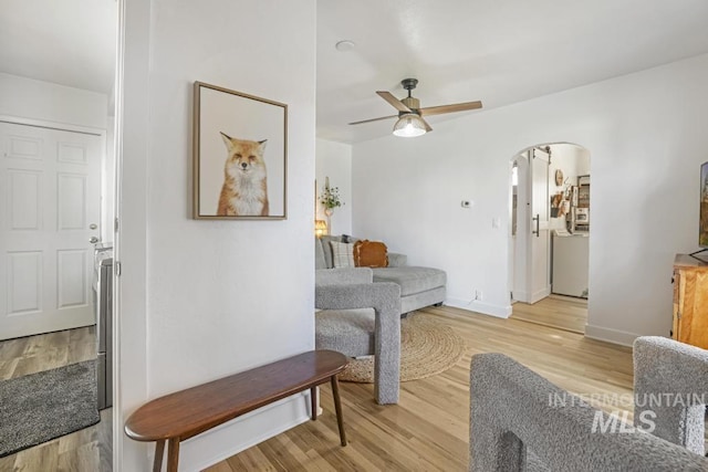 1138 Normal Ave, Burley, ID 83318 - living room with arched walkways, light wood-style floors, ceiling fan, and baseboards