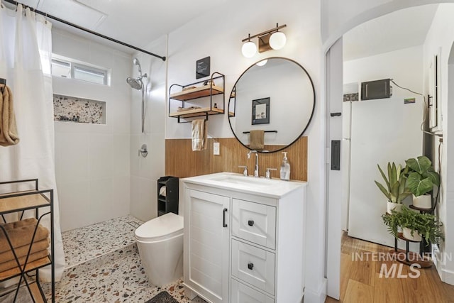 1138 Normal Ave, Burley, ID 83318 - bathroom featuring tiled shower, vanity, toilet, wood walls, and wainscoting