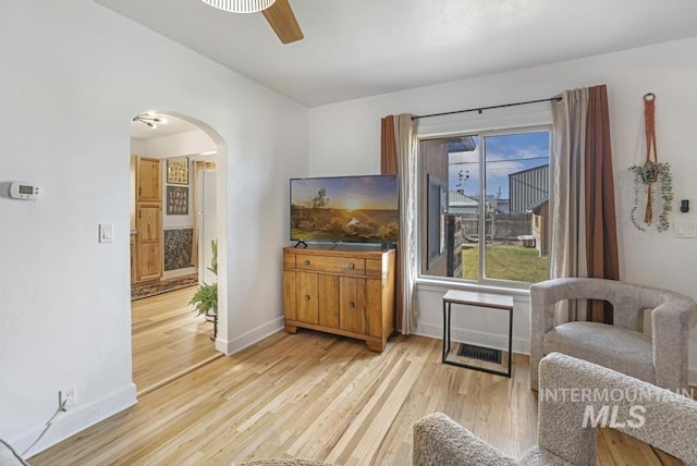 1138 Normal Ave, Burley, ID 83318 - living area with arched walkways, light wood-type flooring, baseboards, and a ceiling fan