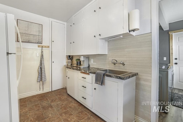 1138 Normal Ave, Burley, ID 83318 - kitchen featuring freestanding refrigerator, dark countertops, white cabinets, and stone finish flooring