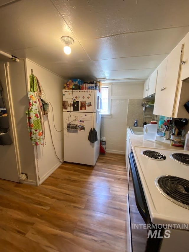 1138 Normal Ave, Burley, ID 83318 - kitchen with freestanding refrigerator, electric stove, light wood-style flooring, and white cabinetry