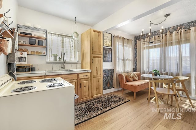 1138 Normal Ave, Burley, ID 83318 - kitchen featuring white range with electric cooktop, a sink, light wood-style floors, a chandelier, and tile counters