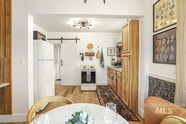 1138 Normal Ave, Burley, ID 83318 - kitchen with range with electric stovetop, freestanding refrigerator, light wood-style floors, a barn door, and baseboards