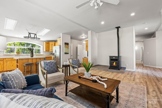 315 Bard Ave, Middleton, ID 83644 - living area featuring a wood stove, light wood-style flooring, ceiling fan, a skylight, and baseboards