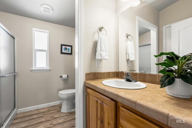 315 Bard Ave, Middleton, ID 83644 - bathroom with vanity, wood finished floors, toilet, an enclosed shower, and baseboards