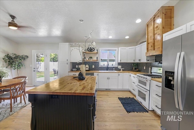 1827 Targhee Dr, Twin Falls, ID 83301 - kitchen with stainless steel refrigerator with ice dispenser, range with two ovens, butcher block countertops, plenty of natural light, and a textured ceiling