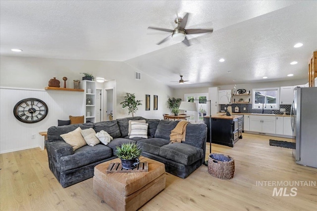 1827 Targhee Dr, Twin Falls, ID 83301 - living room with ceiling fan, lofted ceiling, light wood-style floors, and a textured ceiling