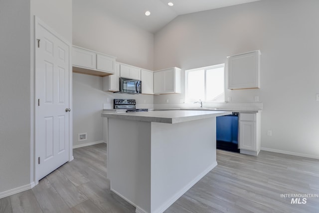 11922 W Box Canyon St, Star, ID 83669 - kitchen with black microwave, electric range oven, high vaulted ceiling, dishwashing machine, and white cabinets