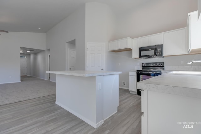 11922 W Box Canyon St, Star, ID 83669 - kitchen with black appliances, a sink, high vaulted ceiling, white cabinets, and light countertops