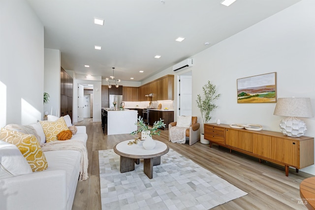 55 E State St Unit 303, Eagle, ID 83616 - living room with light hardwood / wood-style floors, an AC wall unit, and an inviting chandelier