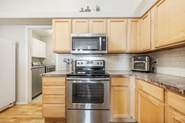 3189 S Kramer Ln, Boise, ID 83706 - kitchen with backsplash, appliances with stainless steel finishes, washing machine and dryer, and light brown cabinets