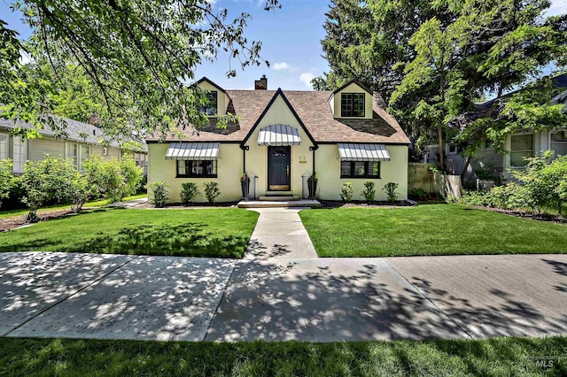 913 N 22nd St, Boise, ID 83702 - tudor home with a chimney, a front lawn, stucco siding, and a shingled roof