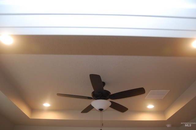 room details featuring ceiling fan and a raised ceiling