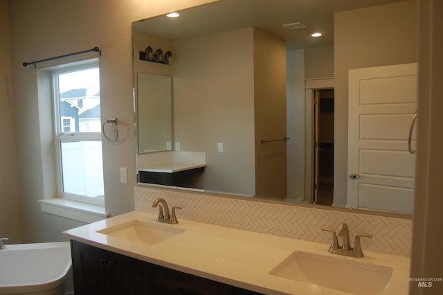 bathroom with vanity and decorative backsplash