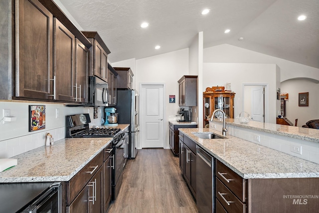 kitchen featuring dark brown cabinetry, black appliances, vaulted ceiling, and a sink