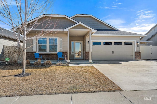 view of front of property featuring a porch, an attached garage, fence, driveway, and a gate