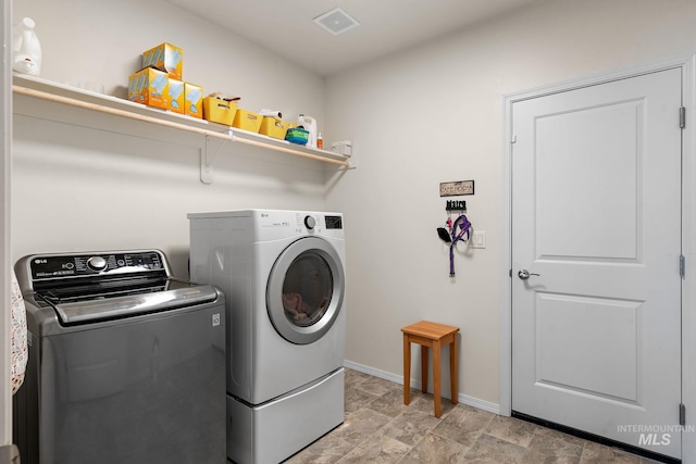 laundry room featuring laundry area, separate washer and dryer, visible vents, and baseboards