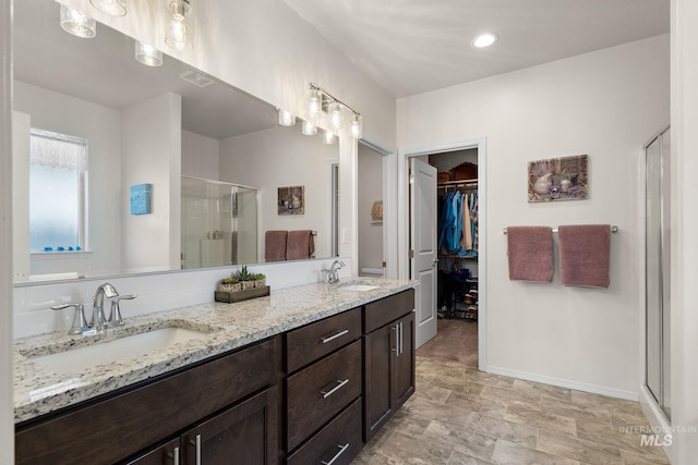 full bath with a shower stall, a spacious closet, visible vents, and a sink