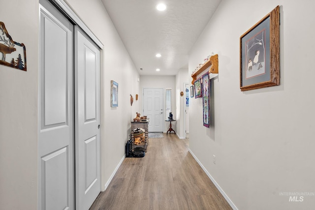 hall featuring recessed lighting, wood finished floors, and baseboards