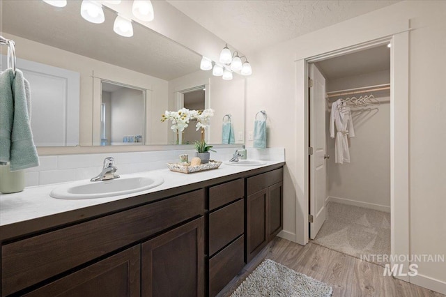 bathroom featuring hardwood / wood-style flooring, vanity, and a textured ceiling